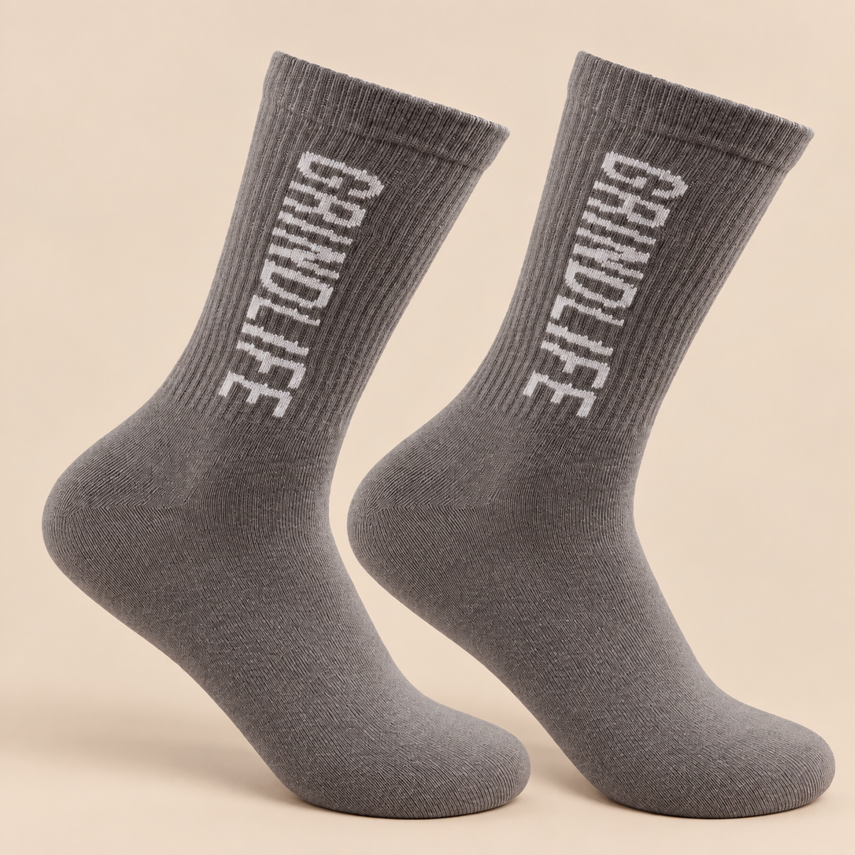 Heather gray Everyday Grind socks on a warm Grind Cream studio background