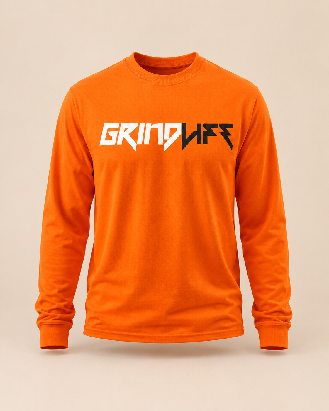 Smashin’ Pumpkin orange long-sleeve tee on a warm Grind Cream studio background